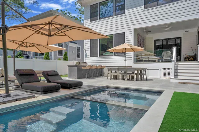 a view of a patio with couches table and chairs under an umbrella