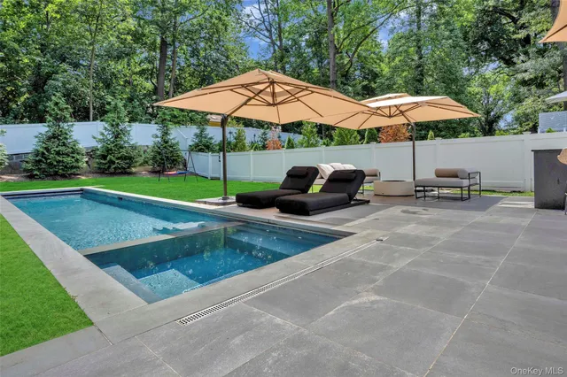 a view of pool with table and chairs under an umbrella