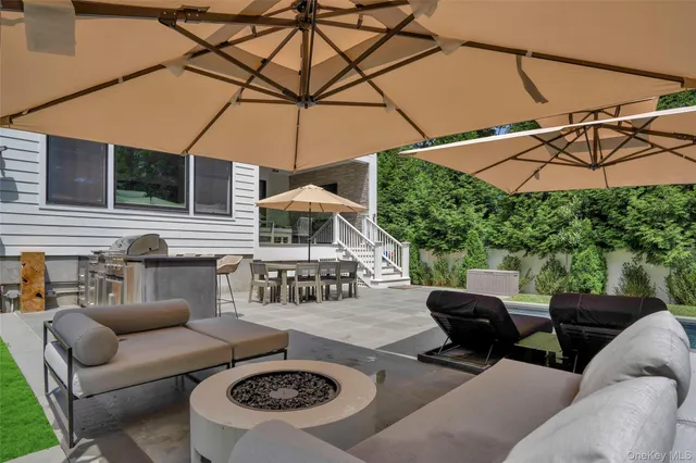 a view of a patio with a table and chairs under an umbrella