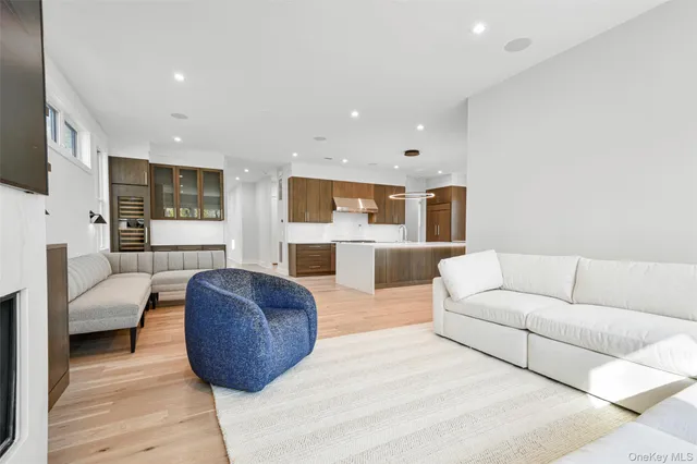 a living room with furniture a flat screen tv and kitchen view