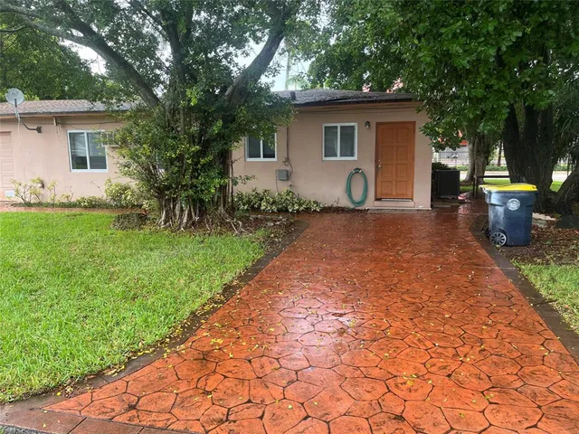 a view of a backyard with potted plants and large trees