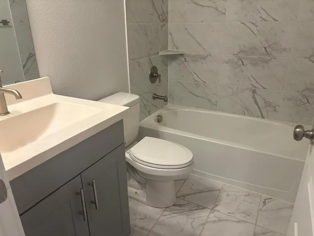 a bathroom with a toilet and a bath tub