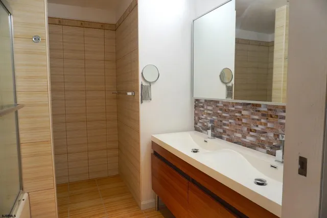 a bathroom with a sink a mirror and shower