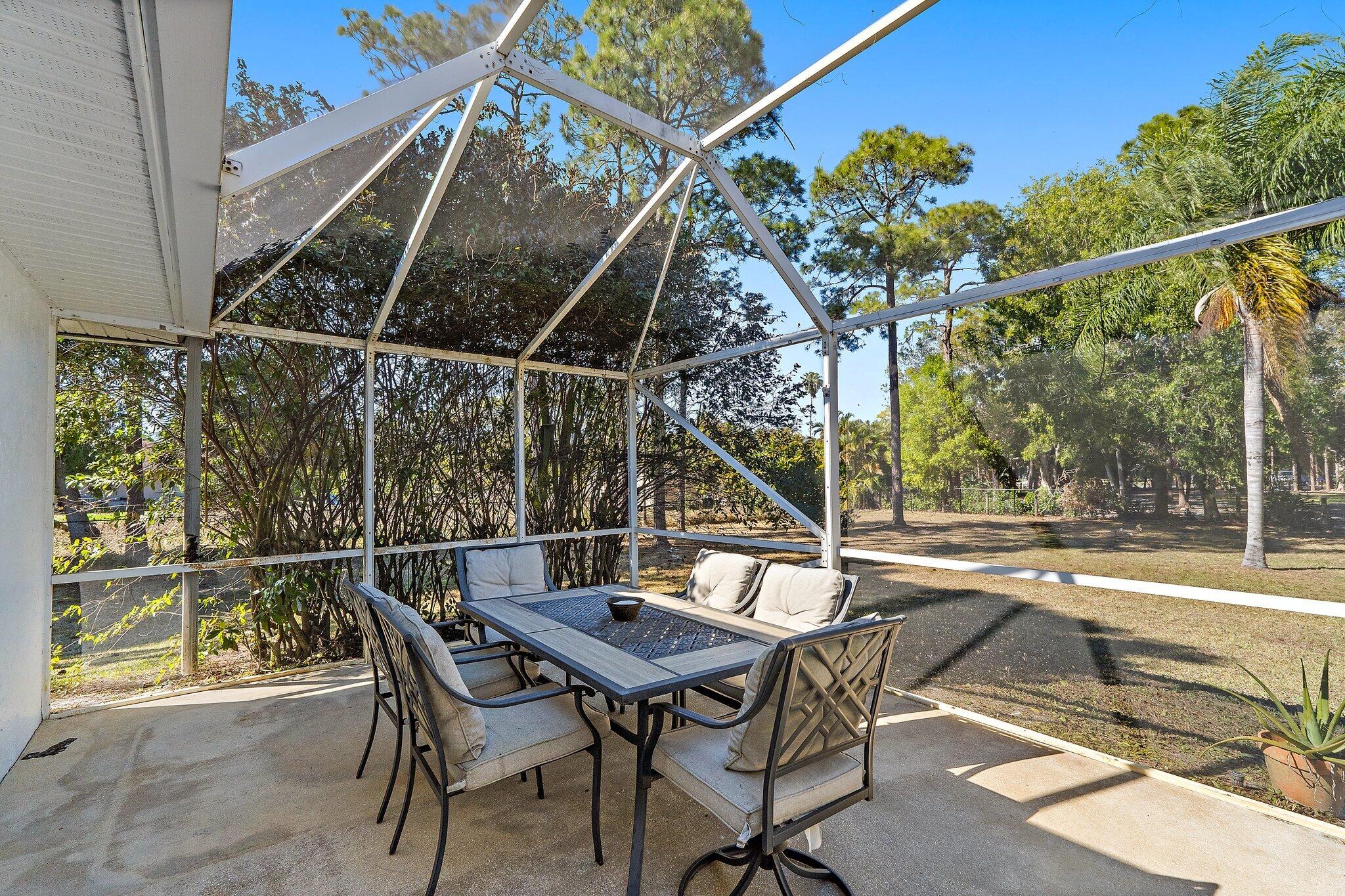 18389 41st Road North Loxahatchee, FL 33470 - Photo 25 of 33 a view of a roof deck with table and chairs with wooden floor and fence
