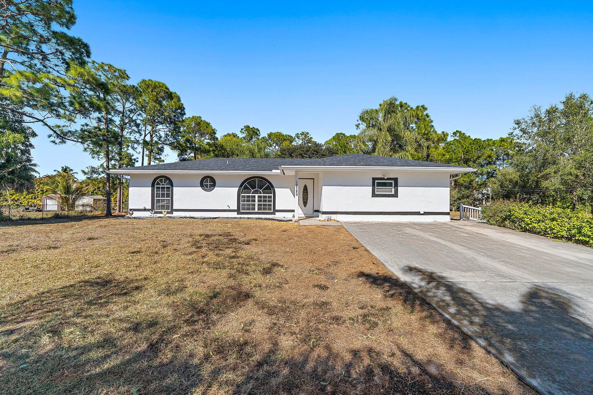 18389 41st Road North Loxahatchee, FL 33470 - Photo 3 of 33 front view of a house with a yard