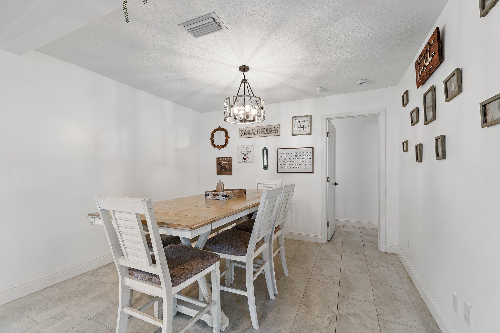 18389 41st Road North Loxahatchee, FL 33470 - Photo 7 of 33 a dining room with a wooden table and chairs