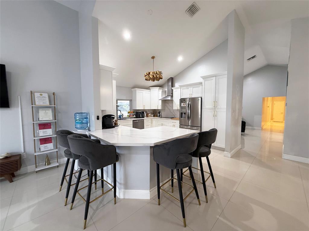 6530 Southwest 172nd Avenue Southwest Ranches, FL 33331 - Photo 20 of 42 a kitchen with a dining table chairs and refrigerator