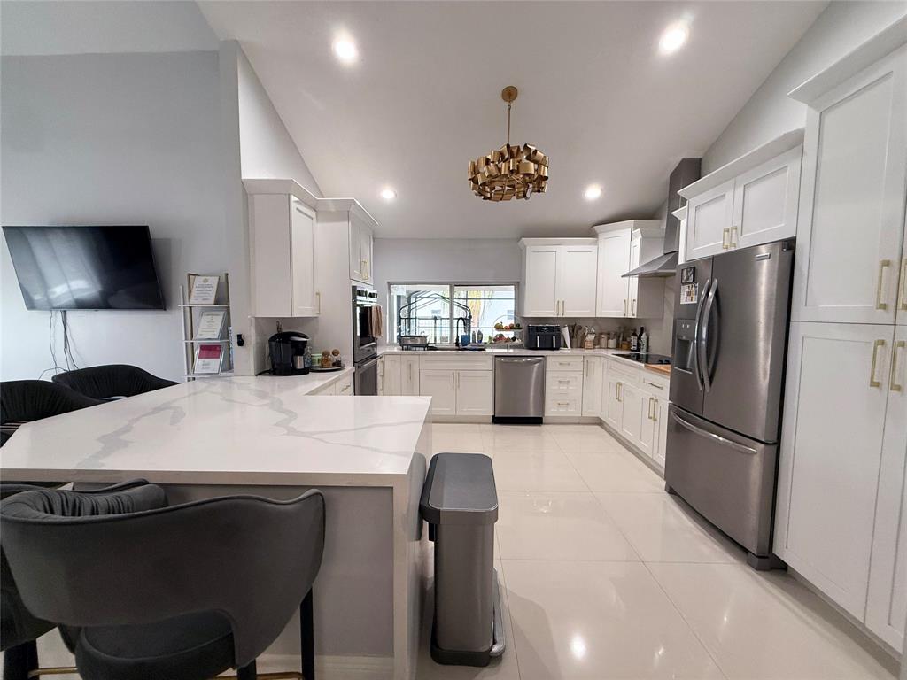 6530 Southwest 172nd Avenue Southwest Ranches, FL 33331 - Photo 21 of 42 a large kitchen with kitchen island a large counter top stainless steel appliances and cabinets