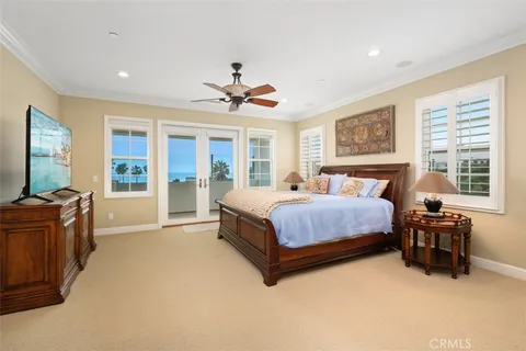 a spacious bedroom with a large bed and a chandelier