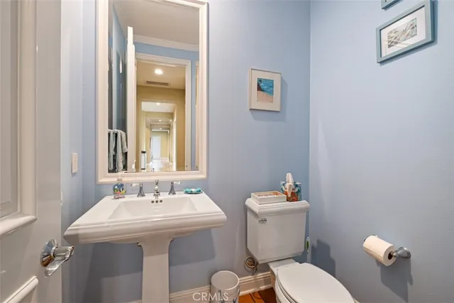 a bathroom with a sink mirror and a toilet
