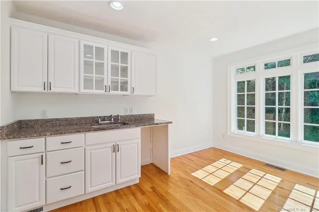 a view of a kitchen with granite countertop wooden cabinets and a window