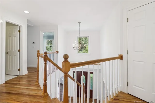 a view of a hallway with wooden floor and stairs