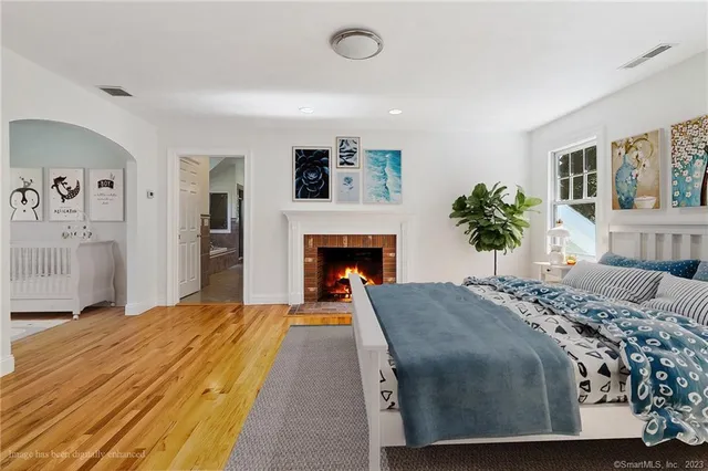 a bedroom with a large bed and a fireplace