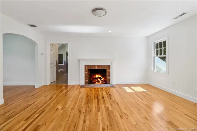 a view of an empty room with a fireplace and a window