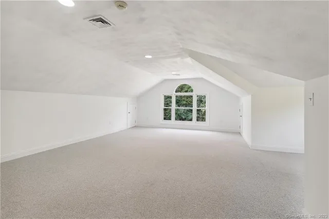 an empty room with windows and ceiling fan