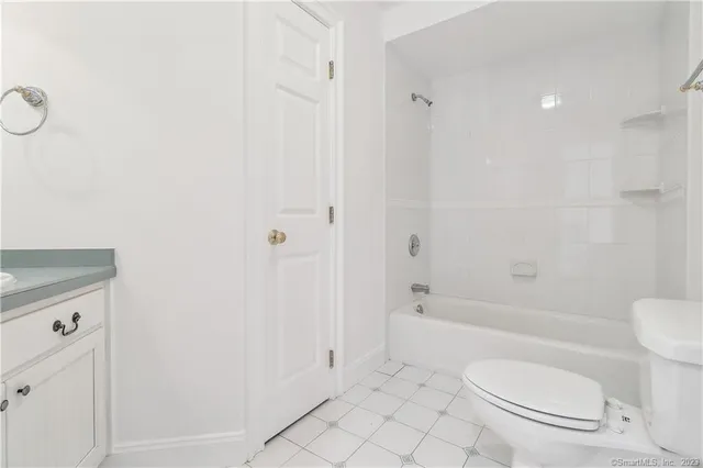 a bathroom with a granite countertop toilet a sink and a bathtub