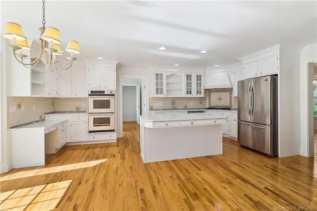 a kitchen with a refrigerator sink and cabinets