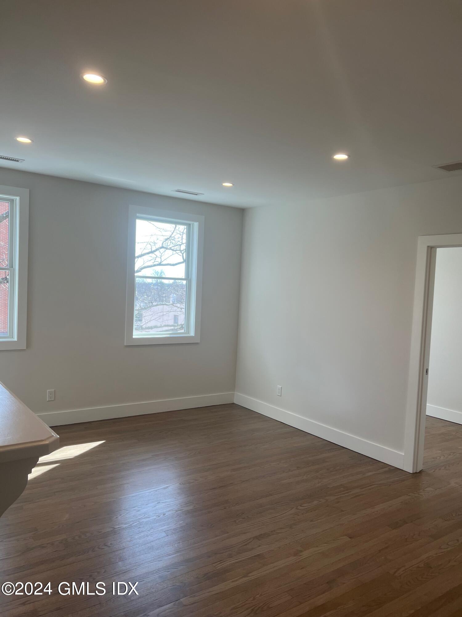 54 Greenwich Avenue, Unit 3 Greenwich, CT 06830 - Photo 22 of 30 an empty room with wooden floor and windows