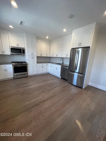 a kitchen with stainless steel appliances a refrigerator and a stove top oven