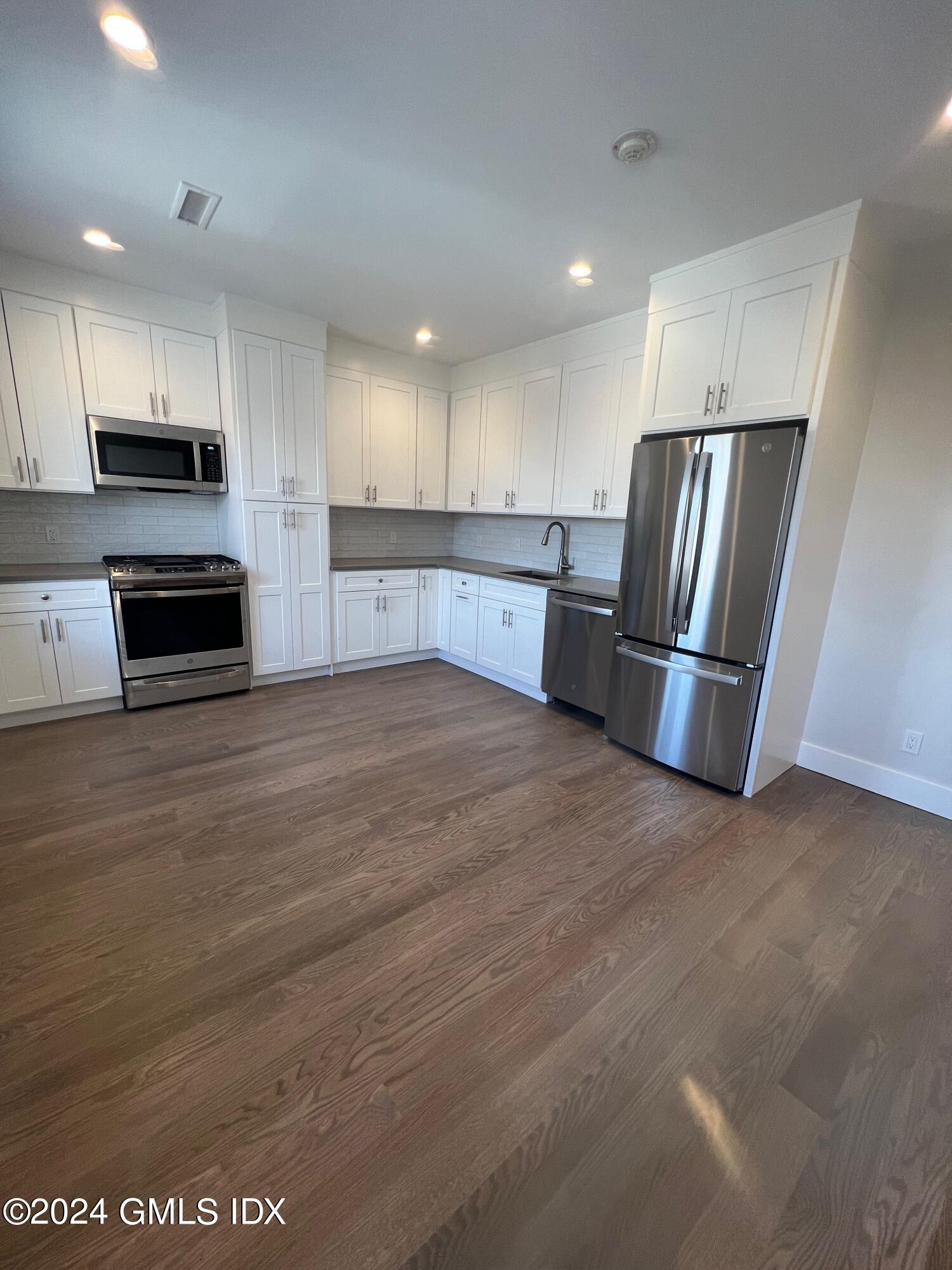 54 Greenwich Avenue, Unit 3 Greenwich, CT 06830 - Photo 4 of 30 a kitchen with stainless steel appliances a refrigerator and a stove top oven