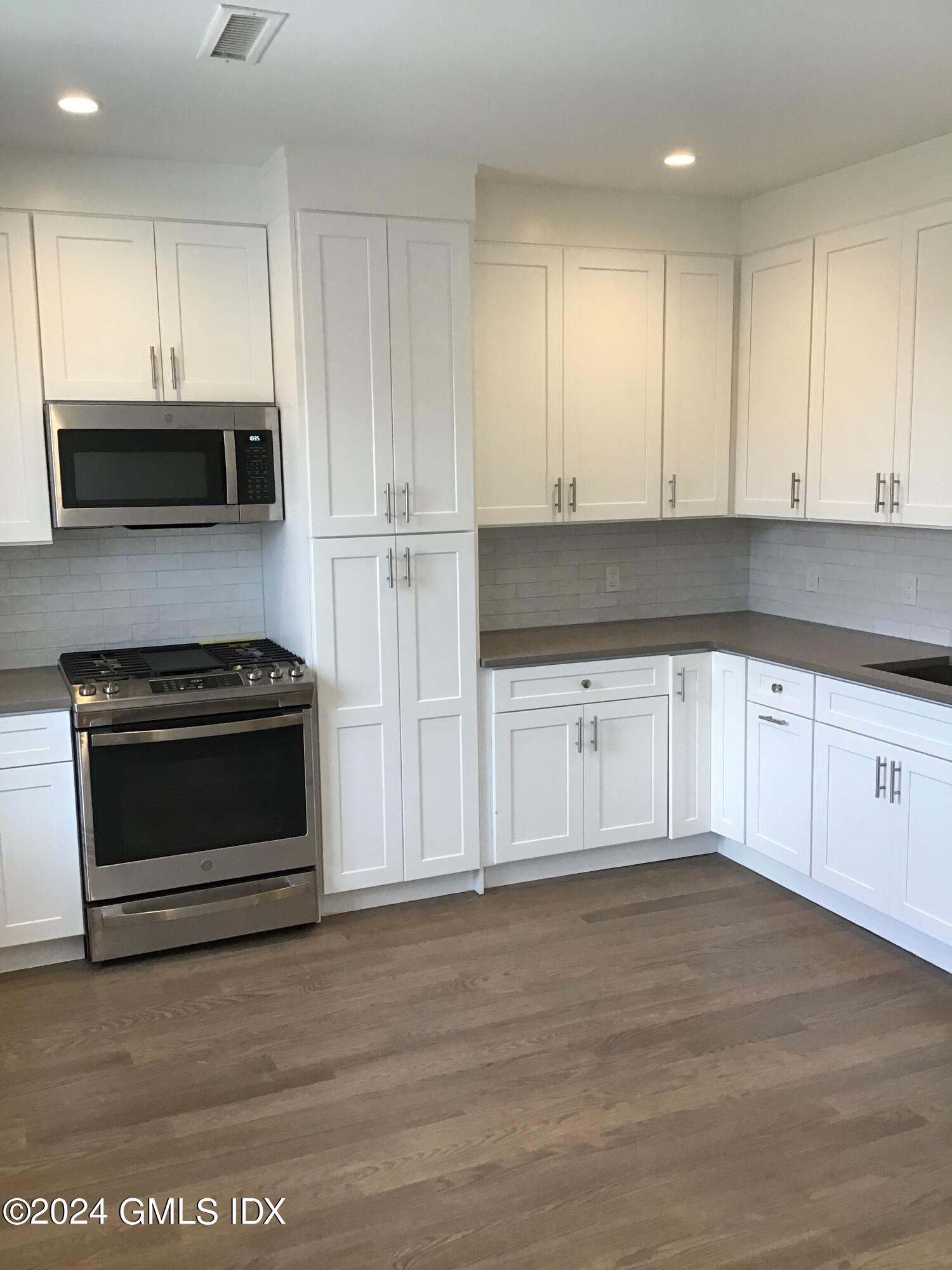 54 Greenwich Avenue, Unit 3 Greenwich, CT 06830 - Photo 5 of 30 a kitchen with white cabinets and stainless steel appliances