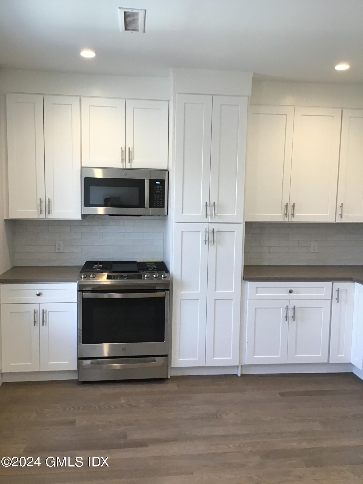 54 Greenwich Avenue, Unit 3 Greenwich, CT 06830 - Photo 6 of 30 a kitchen with granite countertop white cabinets and stainless steel appliances