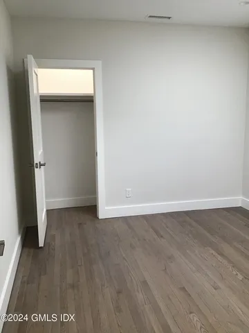 an empty room with wooden floor and closet