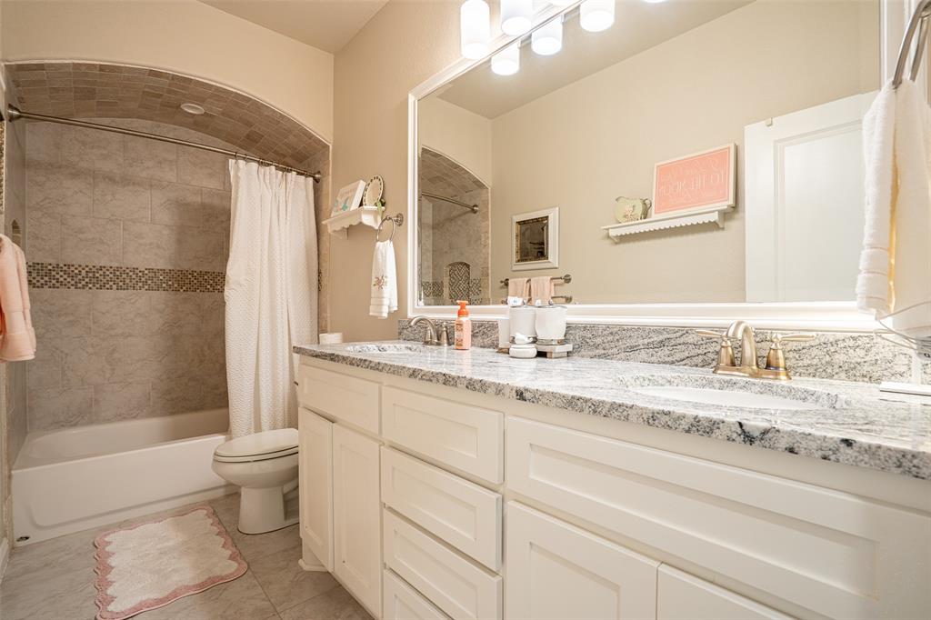 1920 Meander Road Granbury, TX 76049 - Photo 21 of 40 Dual sink vanity with white cabinetry and a speckled countertop