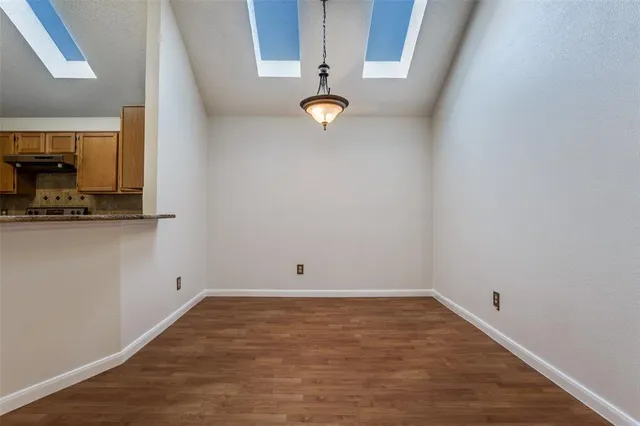 a view of a room with wooden floor and white walls