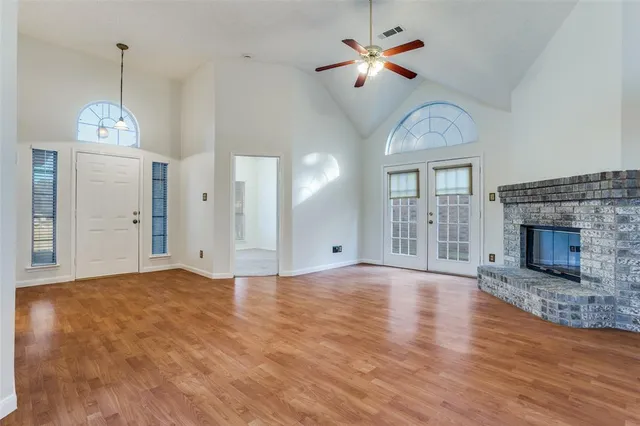 a view of empty room with wooden floor and fireplace