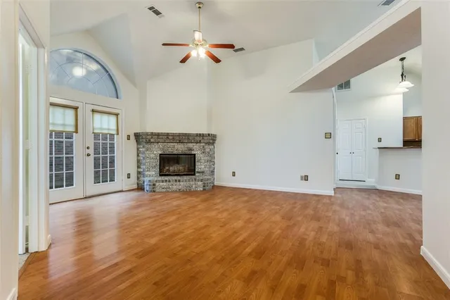 a view of empty room with wooden floor and fireplace