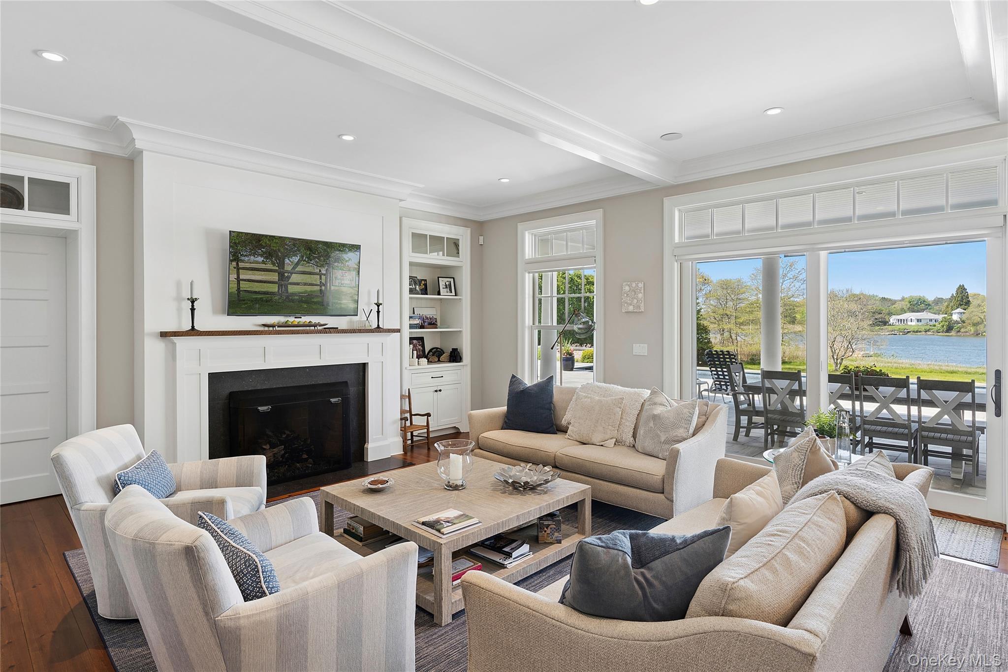 43 Old Main Road Quogue, NY 11959 - Photo 10 of 28 a living room with furniture a fireplace and a large window