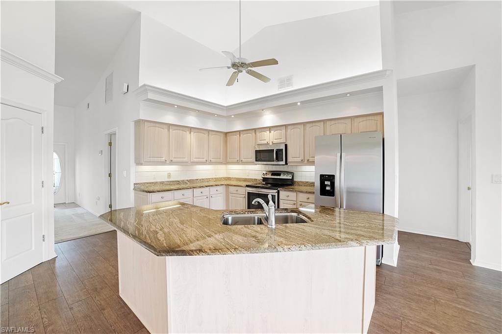 10969 Phoenix Way Naples, FL 34119 - Photo 6 of 20 a kitchen with stainless steel appliances granite countertop a sink a stove and a refrigerator