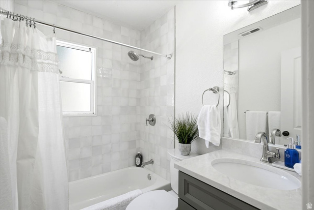 307 Flint Street Layton, UT 84041 - Photo 10 of 13 Bathroom featuring a full vanity with a stone countertop, an undermount sink, and a framed mirror