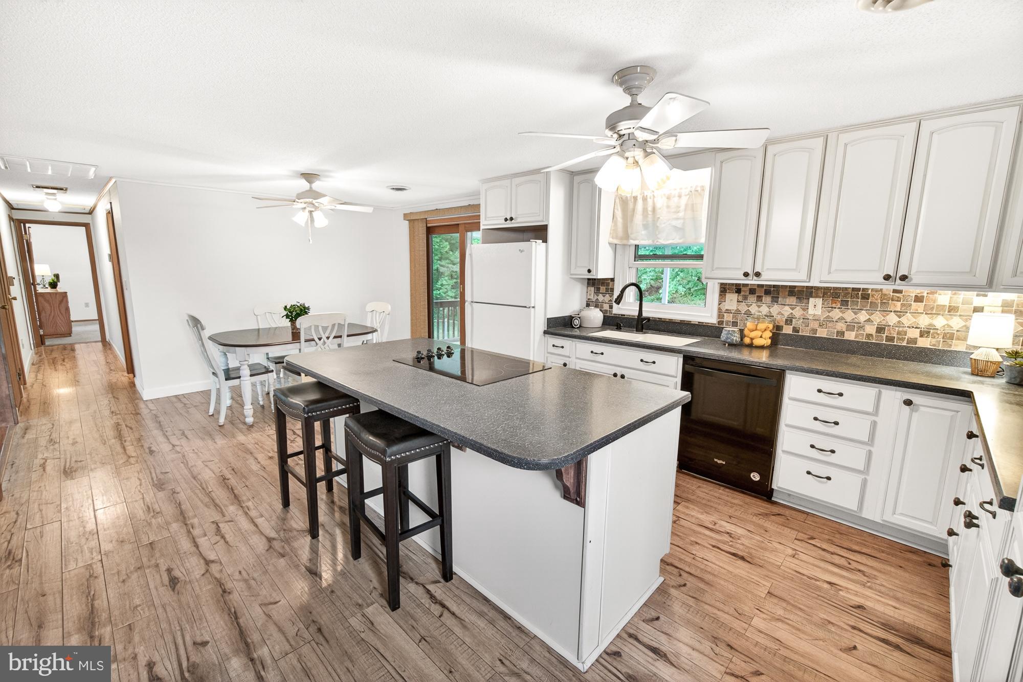 5601 Woodville Road Mount Airy, MD 21771 - Photo 10 of 54 a kitchen with a table chairs and wooden floor