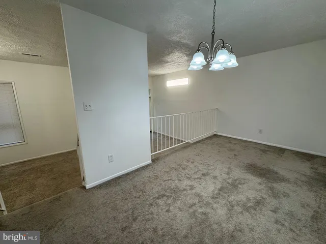 a view of a room with a chandelier fan and a rug