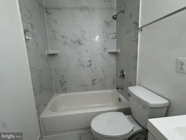 a white toilet and tub sitting next to a bathroom