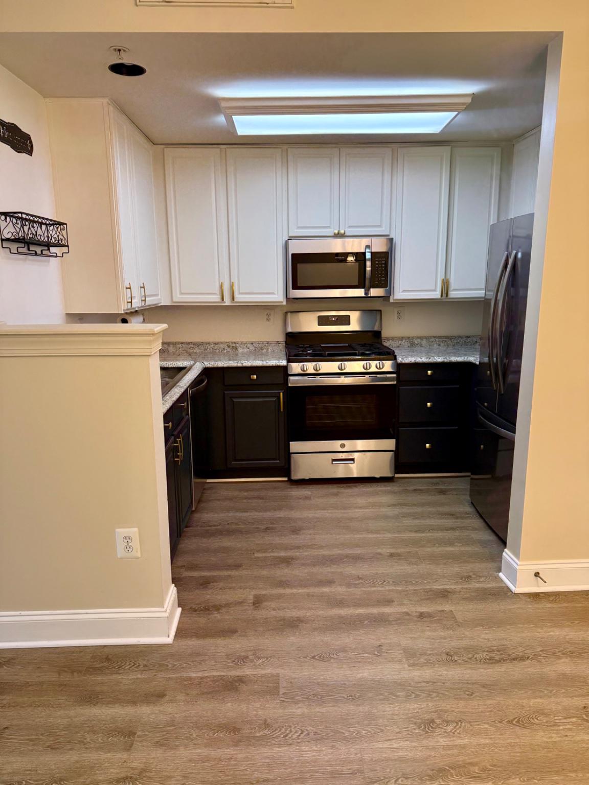 680 Orchard Ridge Drive, Unit 100 Gaithersburg, MD 20878 - Photo 8 of 25 a kitchen with kitchen island granite countertop wooden cabinets and a stove
