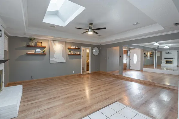 a view of an empty room with window and wooden floor