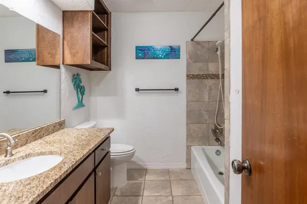 a bathroom with a granite countertop sink a mirror and a toilet