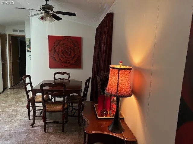 a view of a dining room with furniture and a chandelier fan