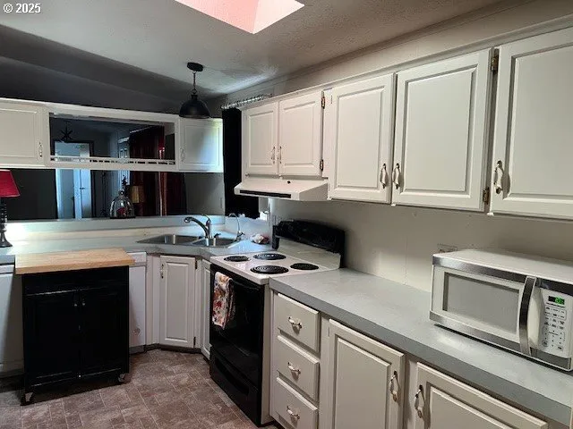 a kitchen with stainless steel appliances granite countertop a stove a sink and a microwave