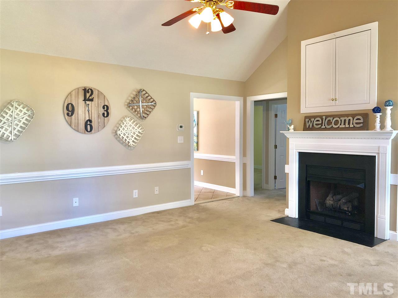 8211 Byrd Road Sims, NC 27880 - Photo 4 of 8 a view of a livingroom with a fireplace a ceiling fan and a refrigerator