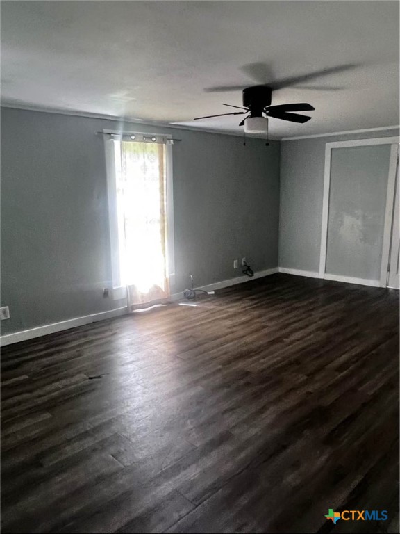 706 East Virginia Avenue Victoria, TX 77901 - Photo 3 of 9 an empty room with wooden floor cabinet and windows