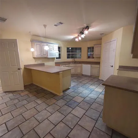 a kitchen with kitchen island a sink counter top and stainless steel appliances