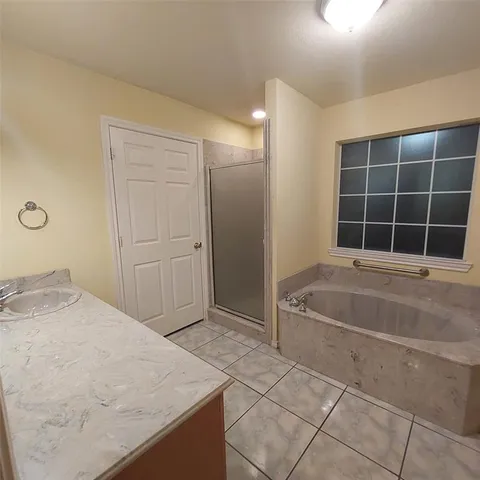 a bathroom with a tub sink and shower