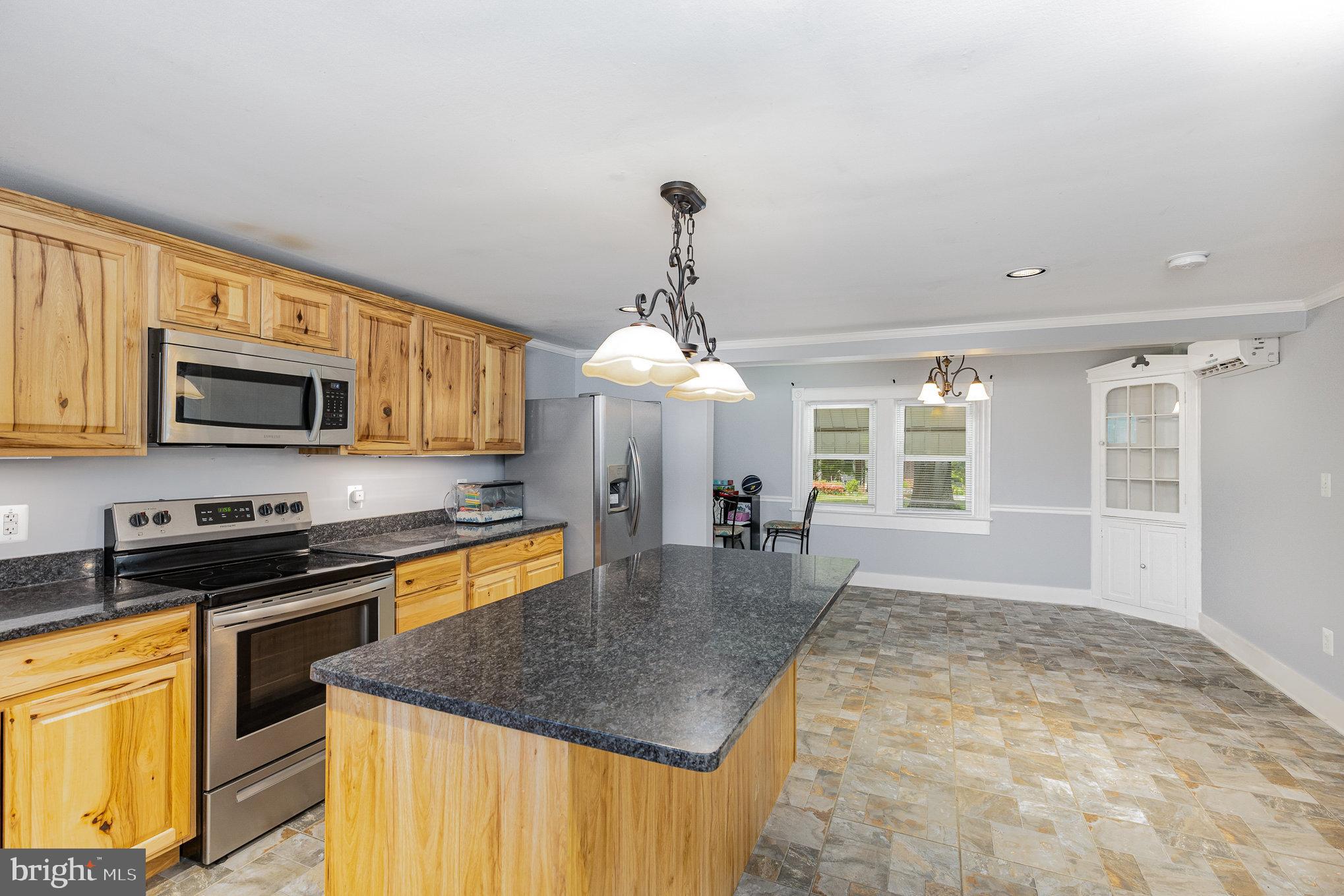 1030 White Oak Road Fredericksburg, VA 22405 - Photo 9 of 25 a kitchen with stainless steel appliances granite countertop a stove top oven a sink a dining table and chairs with wooden floor