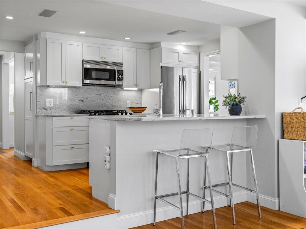 7 Madison Road Wellesley, MA 02481 - Photo 5 of 27 a kitchen with stainless steel appliances kitchen island granite countertop a refrigerator and microwave