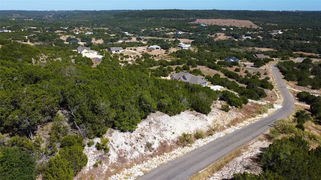 an aerial view of residential houses with outdoor space and trees