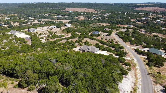 an aerial view of residential houses with outdoor space and trees